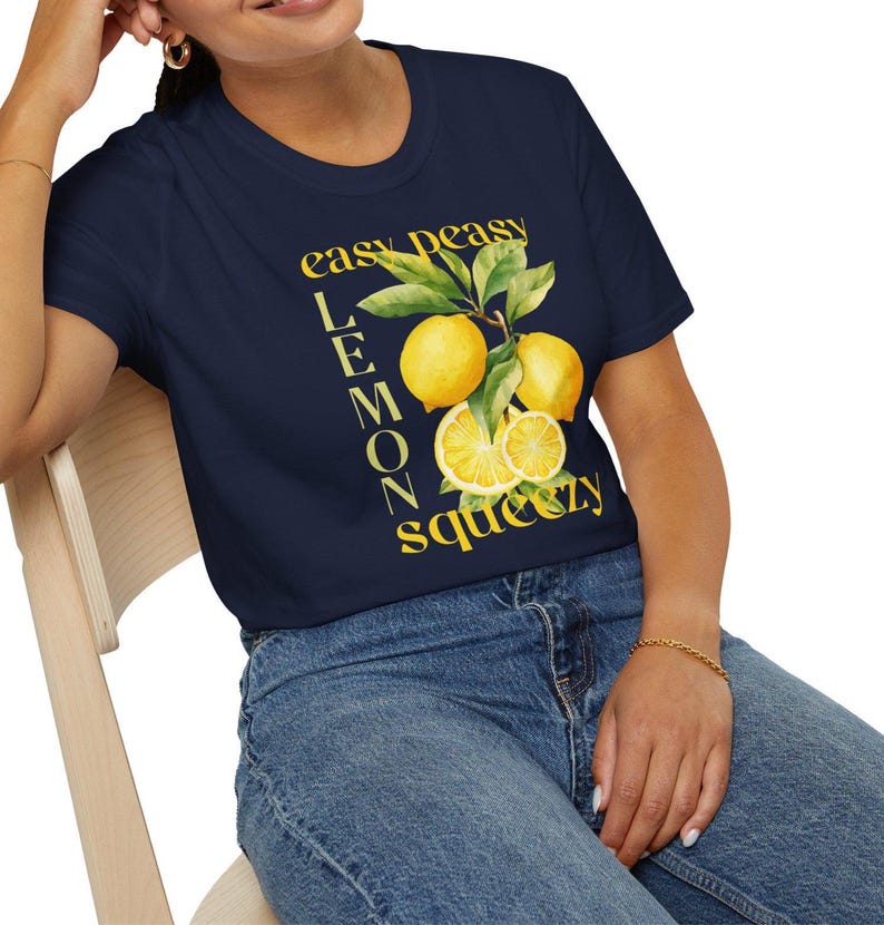 May include: Navy blue t-shirt with a yellow lemon graphic and the text "easy peasy lemon squeezy". The graphic features whole and sliced lemons with green leaves. The shirt is made of a soft, comfortable material.