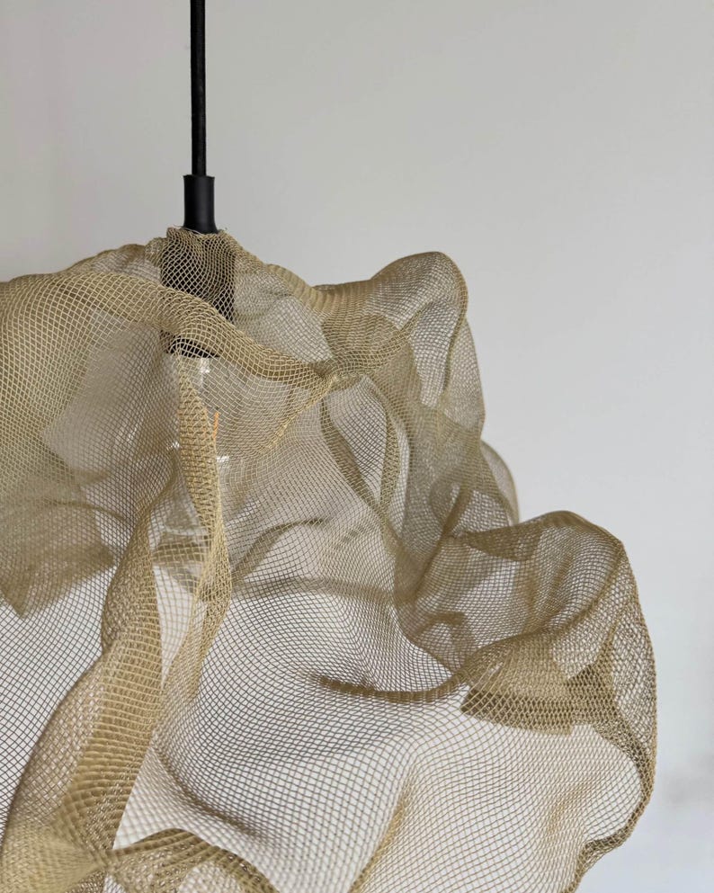 Close-up of a sand-colored wire mesh lampshade, showcasing intricate design and texture.