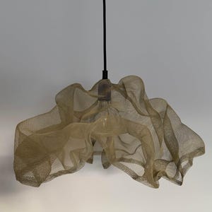 Handcrafted sand-colored wire mesh pendant light casting soft shadows in a modern space.
