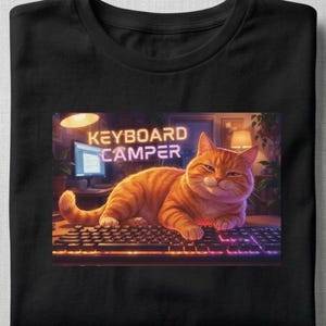 Illustrated cat lounging across a computer keyboard, paws stretched over the keys, with a contented expression. Funny cat lover graphic printed on a t-shirt