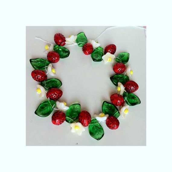 Strawberry beads with blossom and a leaf