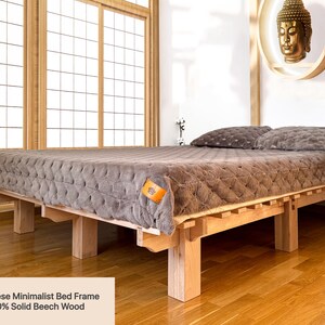 Handmade solid beech wood platform bed with Japanese-inspired design in a bright minimalist bedroom