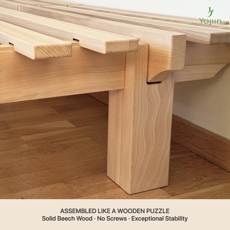 May include: Close-up of a wooden bed frame made of solid beech wood. The frame is assembled without screws, showcasing a puzzle-like construction. The text at the bottom reads: "ASSEMBLED LIKE A WOODEN PUZZLE, Solid Beech Wood, No Screws, Exceptional Stability."