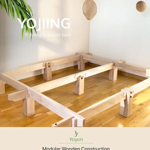 Solid beech wood Japanese bed frame shown during assembly, highlighting the modular interlocking construction and tool-free design.