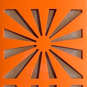 Puede incluir: Panel decorativo rectangular naranja con un diseño de rayos de sol repetido. Los rayos de sol están recortados del panel, revelando un fondo neutro. El panel está hecho de un material sólido y opaco.