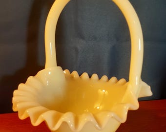 Beautiful vintage Fenton gloss custard glowing ruffled basket. Great collector's item. 7.5" x 6.5" x 5.5". Fenton mark. Excellent condition.