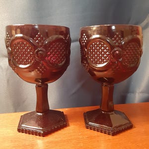 Puede incluir: Dos copas de vidrio rojo oscuro con base hexagonal y un patrón de diamante en el cuenco.