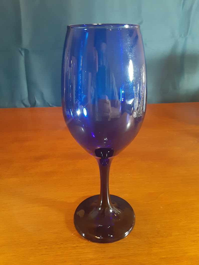 May include: A cobalt blue wine glass with a tall stem and a round base.