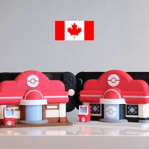 May include: Two red and white building-shaped Nintendo Switch docks with a matching small kiosk. The docks are designed to look like a Pokemon Center. A Canadian flag is in the background.