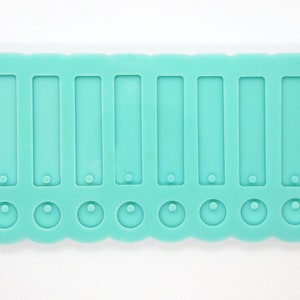 Może przedstawiać: Turkusowa silikonowa forma z dziesięcioma prostokątnymi i dziesięcioma okrągłymi wnękami. Forma jest przeznaczona do tworzenia biżuterii z żywicy.