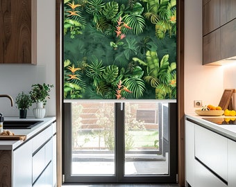 May include: A white window blind with a tropical print featuring green leaves and orange flowers. The blind is partially rolled up, revealing a view of a backyard.