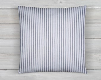 May include: A white pillow with thin, dark blue stripes. The pillow is made of a soft, textured fabric.