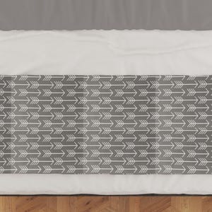 May include: A gray and white patterned bed runner with a white background and a repeating pattern of white arrows on a gray background.