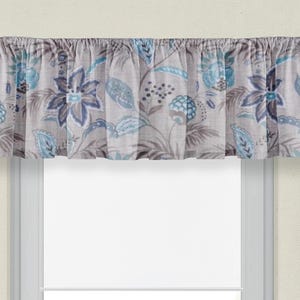May include: A gray and blue floral patterned valance with a ruffled edge. The valance is made of a lightweight fabric and is perfect for adding a touch of elegance to any window.