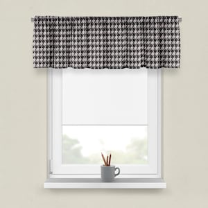 May include: A black and white patterned valance with a white window and a white window sill. There are pencils in a gray cup on the window sill.