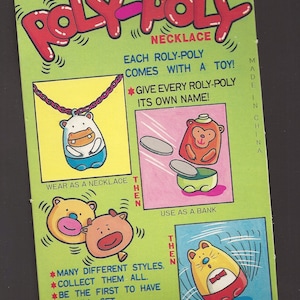 May include: A colorful toy bank and necklace set featuring a cartoon animal with a coin bank and a necklace. The packaging is green and pink with the words "Roly-Poly" and "Coin Bank" printed on it. The toy is made in China.