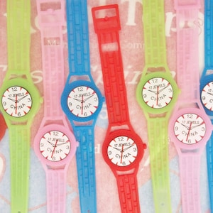 May include: Seven colorful plastic wristwatches with white watch faces that say "17 Jewels" and "China".