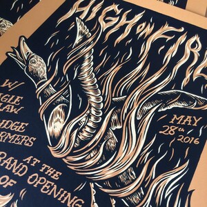 May include: A poster with a stylized illustration of a bird engulfed in flames. The artwork is in shades of tan, white, and navy blue. Text includes "GHONES", "W/ JUNGLE LAW", "MAY 28th 2016", and "GRAND OPENING".