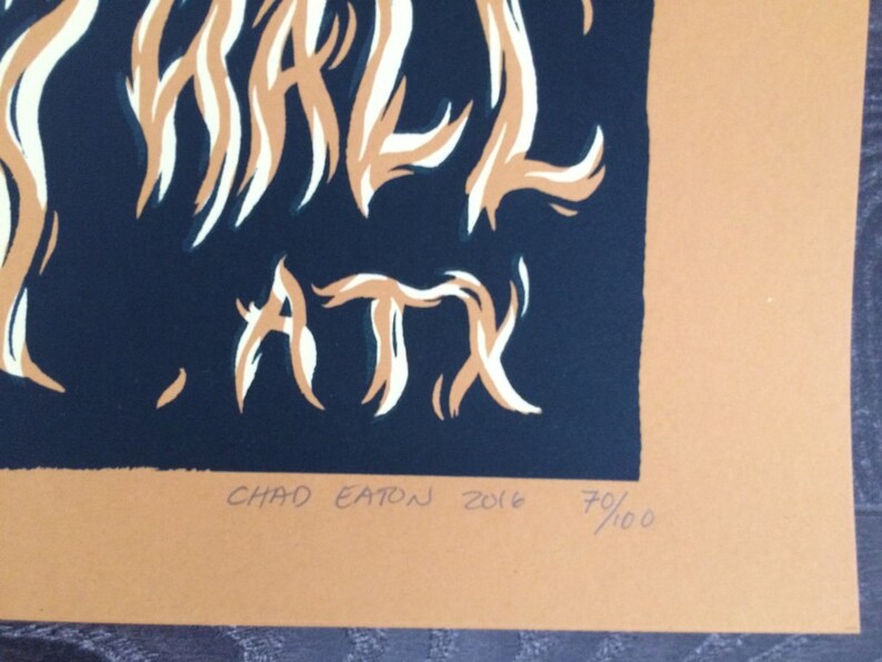 May include: A print with the words "WHALE, ATX" in white and tan against a dark blue background. The print is signed "CHAD EATON 2016" and numbered 70/100. The background is tan.