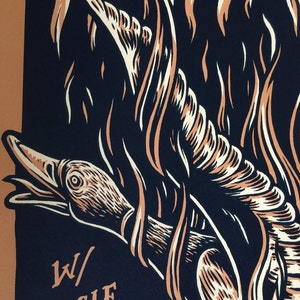 May include: A graphic art print featuring a stylized eagle claw design with flames. The artwork uses a palette of dark blue, beige, and off-white. The text "W/ EAGLE CLAW" is visible in the lower left corner.