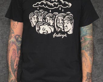 Chad Eaton- FEELINGS- "HEADS" on black t-shirt