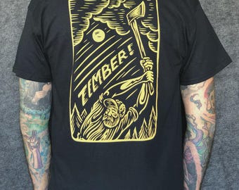 Chad Eaton- TIMBER!- "SWINGER" on black t-shirt