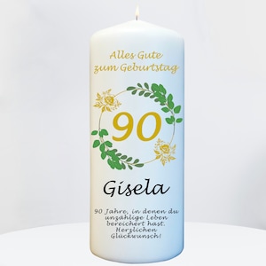 Könnte beinhalten: Weiße Geburtstagskerze mit einem grünen und goldenen Blumengirlanden um die Zahl 90. Der Text "Alles Gute zum Geburtstag" und "Gisela" sind auf der Kerze gedruckt. Der Text "90 Jahre, in denen du unzählige Leben bereichert hast. Herzlichen Glückwunsch!" ist ebenfalls auf der Kerze gedruckt.