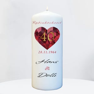 Könnte beinhalten: Weiße Kerze mit einem roten herzförmigen Rubin-Design, die Zahl 40 in goldener Schrift, das Datum 28.11.1964, die Worte "Rubinhochzeit", "Hans" und "Dolli" sowie zwei goldene Ringe.