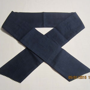 May include: A navy blue sash, likely for a garment, is displayed against a white background. The sash is made of a solid, dark blue fabric. The ends of the sash are cut with a decorative, scalloped edge. The date and time stamp is visible in the bottom right corner.