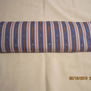 May include: A blue and white striped fabric pillow with a baseball bat and ball pattern. The pillow is folded in half.