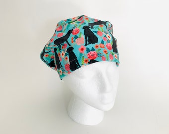 May include: A blue scrub hat with a floral pattern and black silhouettes of Labrador Retrievers.