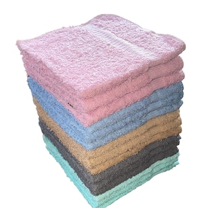 May include: A stack of 10 colorful towels in pink, blue, brown, gray, and green. The towels are folded and stacked neatly.