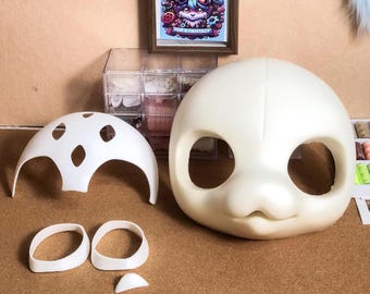 May include: A set of unpainted white resin doll parts including a large rounded head piece with eye sockets, a dome-shaped top piece with cutouts, two oval eye frames, and a small triangular nose piece, all arranged on a flat surface.