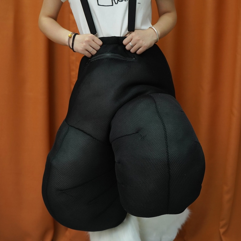 May include: Black padded costume pants with suspenders. The pants have a zippered pocket on the front.