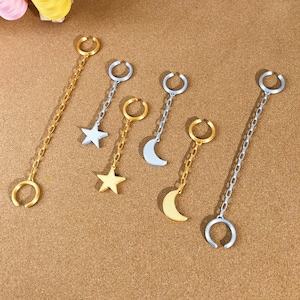 May include: Ear cuffs in gold and silver tones. The ear cuffs feature a chain and a charm in the shape of a star or crescent moon. The ear cuffs are designed to be worn without piercing.