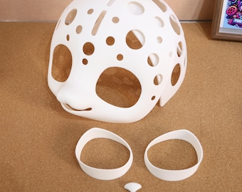 May include: White plastic mask with a face design and holes throughout. The mask is accompanied by two white plastic rings and a small white plastic nose piece.