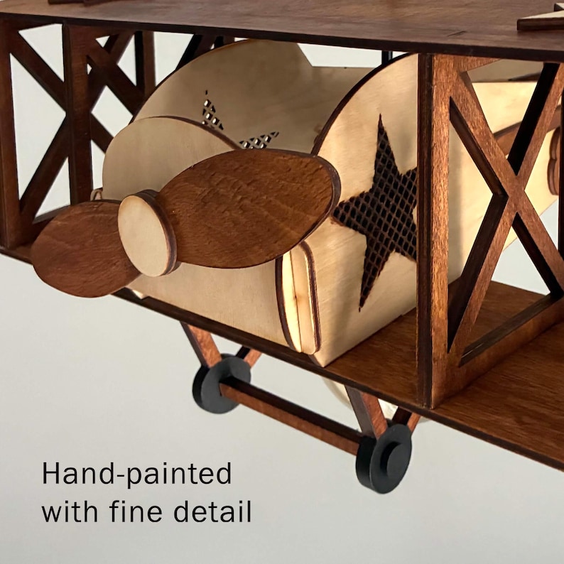 Close-up detail of handmade wooden biplane lamp showing propeller and natural birch wood finish