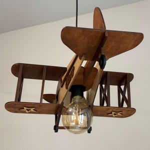 Wooden biplane airplane lamp in natural wood and teak tones – handmade nursery and kids decor.