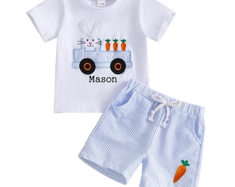 Op de afbeelding: Witte T-shirt en blauwe seersucker short set. Het shirt heeft een geborduurde konijn die een blauwe vrachtwagen met wortels bestuurt, met de naam "Mason" eronder. De shorts hebben een wortel applicatie.