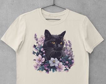 May include: A beige t-shirt with a black cat surrounded by purple and white flowers.