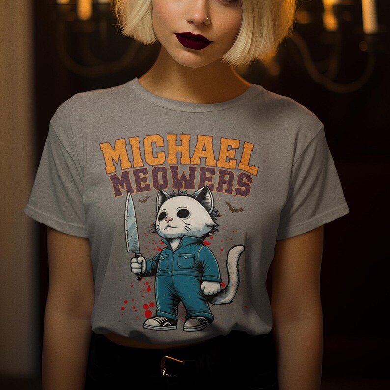 May include: Gray t-shirt with a graphic of a white cat holding a knife. The text "MICHAEL MEOWERS" is printed on the shirt.