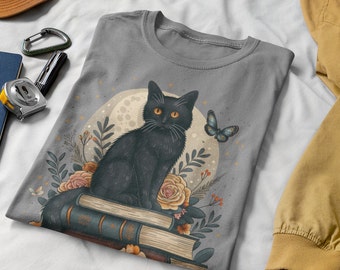 May include: A gray t-shirt with a black cat sitting on a stack of books. The cat has yellow eyes and is surrounded by flowers and a butterfly. The moon is in the background.