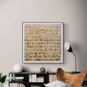 May include: A framed photograph of a wall filled with rows of small glass jars containing various spices and herbs. The jars are arranged in a grid pattern and are all the same size. The photograph is hanging on a white wall above a black bookshelf and a brown leather chair.