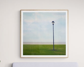 Foto de paisaje minimalista: farola, césped verde y cielo azul