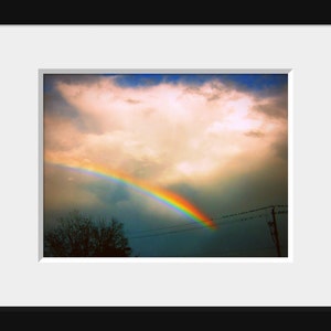 May include: A vibrant rainbow arches across a cloudy sky, with a few birds flying overhead. The rainbow is a symbol of hope and new beginnings.