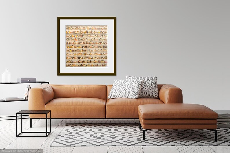 May include: A framed photograph of a wall filled with small, colorful jars. The jars are arranged in a grid pattern and are filled with various objects, such as buttons, beads, and other small trinkets. The photograph is hanging on a white wall in a living room setting.