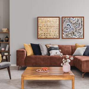 May include: A brown sectional sofa with yellow, blue, and gray throw pillows in a living room with a wooden coffee table, a gray armchair with a yellow pillow, and two framed abstract art prints on the wall.