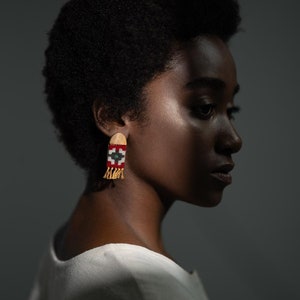 Model wearing LaLan's Saffron Dome Kilim Wooden Earrings, featuring a dome-shaped kilim design with warm saffron tones, framed by walnut wood.