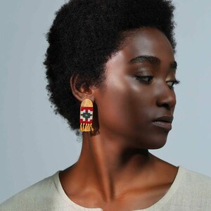 Model wearing LaLan's Saffron Dome Kilim Wooden Earrings, featuring a dome-shaped kilim design with warm saffron tones, framed by walnut wood.
