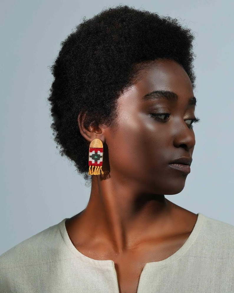 Model wearing LaLan's Saffron Dome Kilim Wooden Earrings, featuring a dome-shaped kilim design with warm saffron tones, framed by walnut wood.